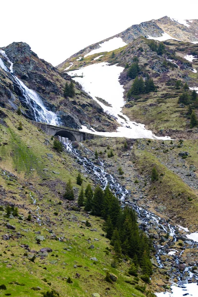 Fiume di montagna scorre lungo il fianco della montagna, neve. Sfondo naturale in primavera o in estate. Focus selettivo . — Foto Stock