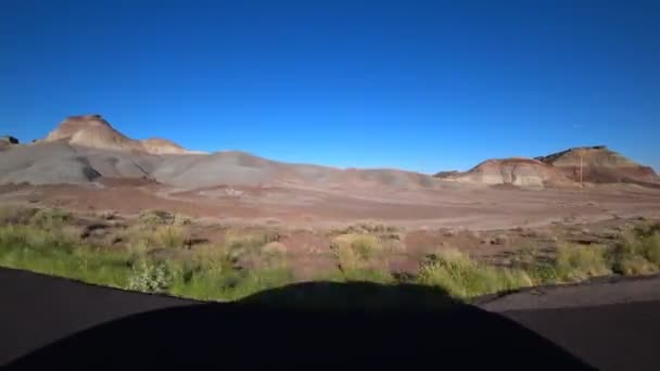 Θέα των κόκκινων βουνών της ερήμου στην Καλιφόρνια. Η κίνηση του αυτοκινήτου σε ένα επίπεδο δρόμο. Οδικό ταξίδι. — Αρχείο Βίντεο