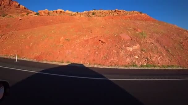 Traffico automobilistico sulle strade della California lungo le montagne rosse luminose. Una vista incredibile. Viaggio in macchina . — Video Stock
