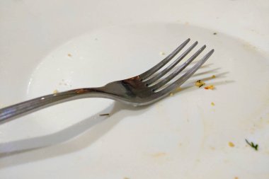 Restoranda yedikten sonra çatallı kirli bir tabak.