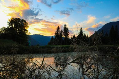 Dağlarda güzel bir gün batımı. Göldeki bulutların yansıması