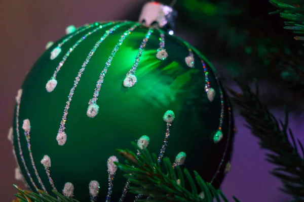 One green Christmas ball on Christmas tree
