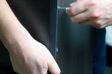 İnsanın elleri ev mobilyalarını monte ederken, inşa ederken