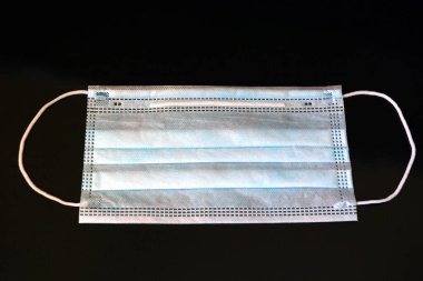 Siyah arka planda koruyucu tıbbi maske. Koronavirüse karşı önlem. Covid - 19