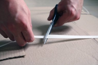 Bir adam karton ambalajlardan toplanmak için mobilyaları boşaltıyor.