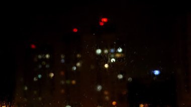 Evin penceresinden gelen ışığın görüntüsü, odak dışı. Gök gürültülü şimşek fırtınası.