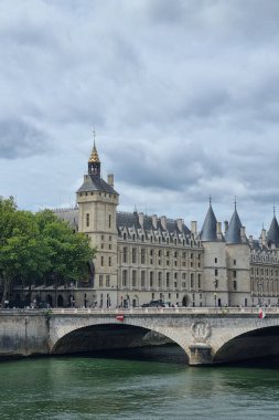 Paris, Fransa, 4 Ağustos 2025: Paris 'teki Seine nehri boyunca ikonik mimariyi bulutlu bir gökyüzü, tarihi taş binalar ve doğal yeşilliklerin karışımı, seyahat meraklıları ve tarihi mimari hayranları için mükemmel..