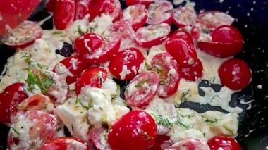 Meyveli domatesler kremalı sosla karıştırılır ve otlarla süslenir, canlı ve iştah açıcı bir yaz salatası yaratır. Yemek fotoğrafçılığı, yemek blogları ya da taze ve sağlıklı yemek fikirlerini gösteren yemek tarifleri kitapları için mükemmel..