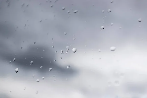 Cam pencereye su damlaları ve arka planda kara bulutlar