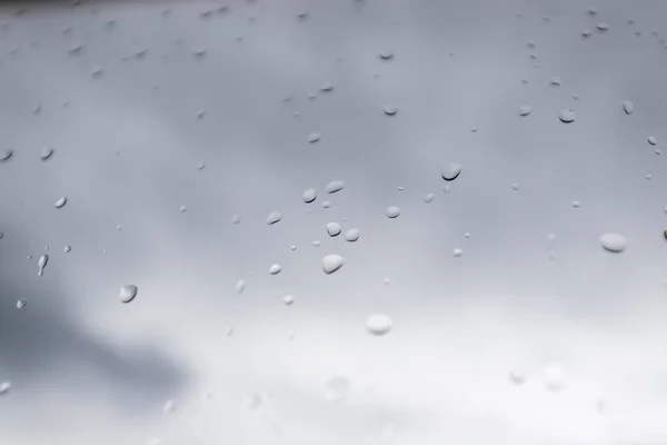Cam pencereye su damlaları ve arka planda kara bulutlar