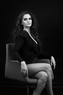 Siyah bir zemin üzerine bir stüdyoda bir kız portresi. Siyah ve beyaz fotoğraf.