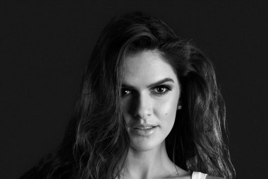 Siyah bir zemin üzerine bir stüdyoda bir kız portresi. Bir kız portresi kapatın. Siyah ve beyaz fotoğraf.