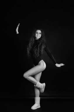 Siyah bir zemin üzerine bir stüdyoda bir kız portresi. Deli kız stüdyoda. Siyah ve beyaz fotoğraf.