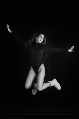 Siyah bir zemin üzerine bir stüdyoda bir kız portresi. Deli kız stüdyoda. Siyah ve beyaz fotoğraf.