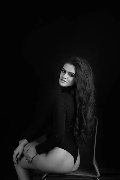 Siyah bir zemin üzerine bir stüdyoda bir kız portresi. Deli kız stüdyoda. Siyah ve beyaz fotoğraf.