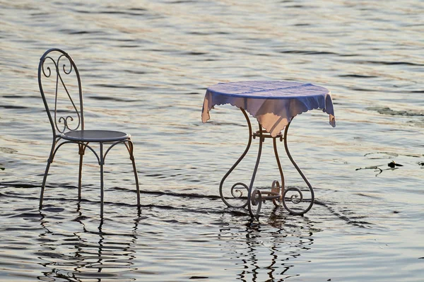 Gorgeous retro table and chair on the lake water.