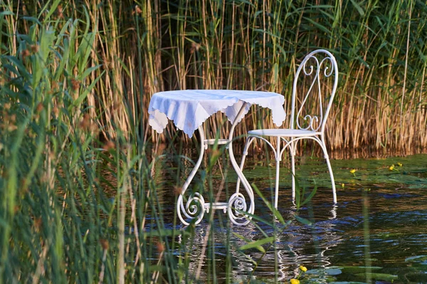 Gorgeous retro table and chair on the lake water.