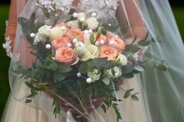 Gelinin elinde düğün buketi.