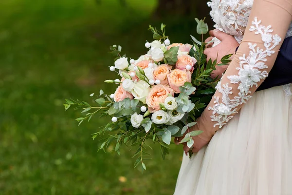 Recién casados sostienen el ramo de bodas en sus manos . — Foto de Stock