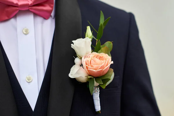 Деталь темно-синего костюма жениха с бутоньеркой из роз . — стоковое фото