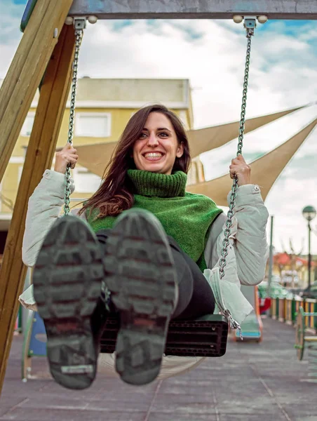 Portrait of Happy attractive hispanic woman playing swinging. hipster style. Cute long hair girl swinging and smiling.