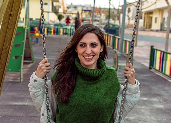 Portrait of Happy attractive hispanic woman playing swinging. hipster style. Cute long hair girl swinging and smiling.