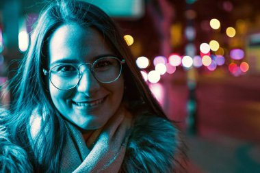 Genç kız renkli neon ışık ile düşük ışık çekim poz