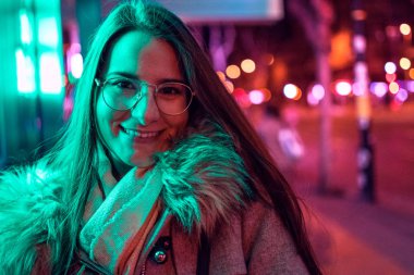 Genç kız renkli neon ışık ile düşük ışık çekim poz