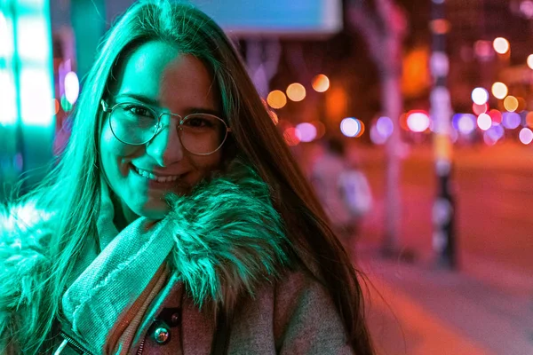 Young girl posing in low light shots with colourful neon light