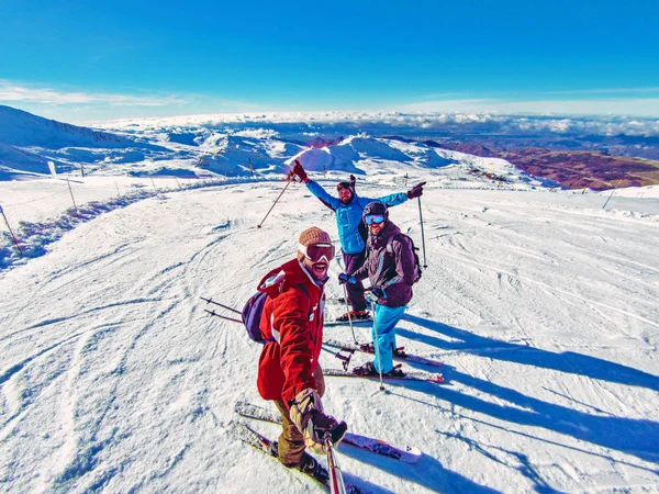 Group of friends skiing on winter holidays at the mountains having fun on the snow