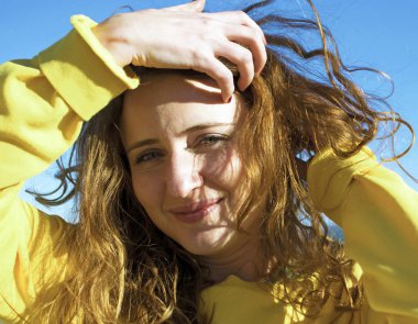 Plajda güzel genç kadın kamera bakıyor. Mutlu sarışın kız Seascape karşı gülümseyen.