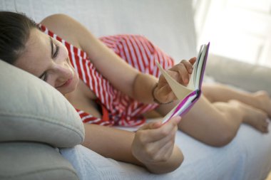 kız kanepede kitap okuma