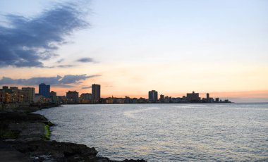 Malecon Promenade üzerinden gün batımında bulutların arkasındaki güneş ışınları