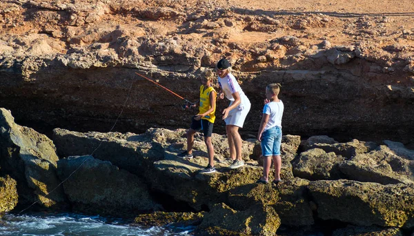 Barcelona, Espanha, 22 de agosto de 2019: Três irmãos se divertem pescando na praia — Fotografia de Stock