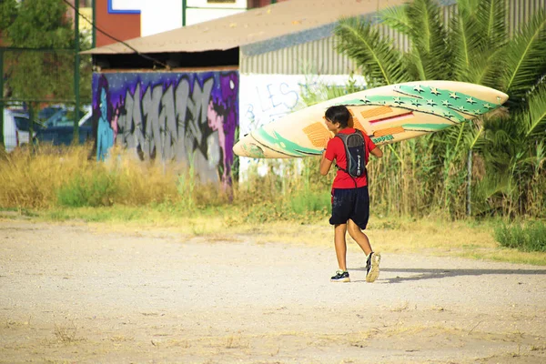 Alicante, Španělsko, 22. srpna 2019: mladý sportovec, který nesl svůj dlouhý bok na pláž — Stock fotografie