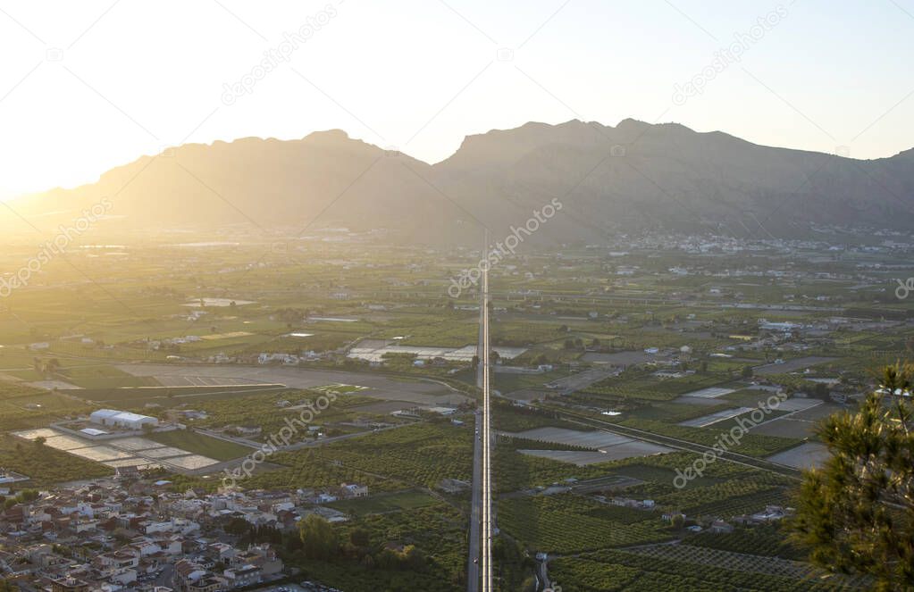 Water transfer from Tajo river to Segura river in Spain. Cityscape of Murcia. Communications of the pipeline above the ground in landscape at sunset.