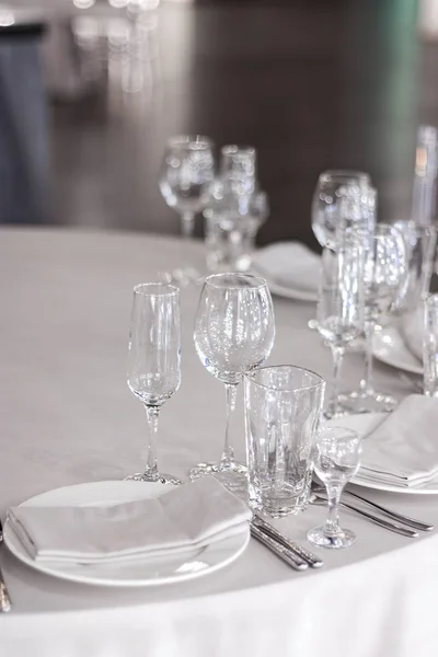 ワイングラスは白いテーブルクロスにテーブルの上にあります テーブルは休暇用に設定されています 皿の上の白いナプキン — ストック写真