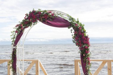 Kemer beyaz kumaş ve çiçekler ile dekore edilmiştir. Sahilde düğün töreni