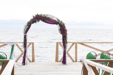 Kemer beyaz kumaş ve çiçekler ile dekore edilmiştir. Düğün töreni körfezin kıyısında