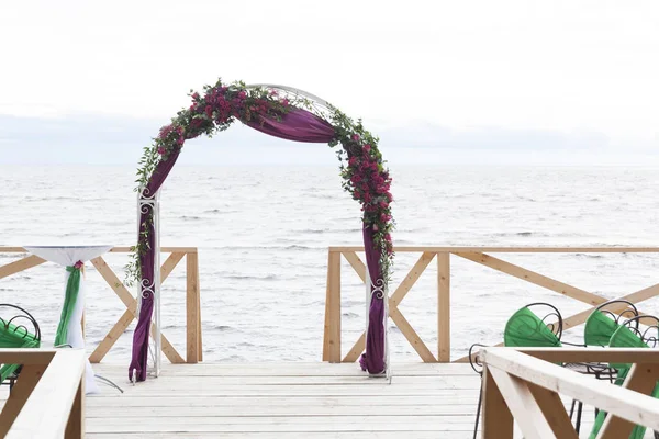 Kemer beyaz kumaş ve çiçekler ile dekore edilmiştir. Düğün töreni körfezin kıyısında