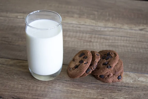 クッキーとミルク テーブルの朝食を木製の背景にミルクとチョコレートのクッキー — ストック写真