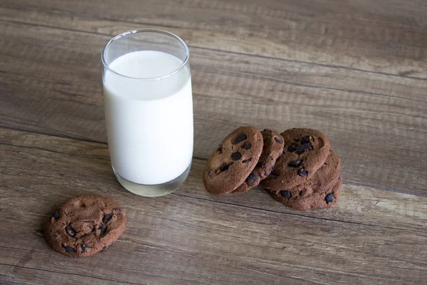 クッキーとミルク テーブルの朝食を木製の背景にミルクとチョコレートのクッキー — ストック写真