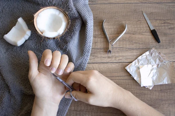 El Bakımı, Halk El Bakımı. Manikür Hindistan cevizi yağı ile manikür araçları: makası, törpü. Folyo Jel Lehçe ahşap arka plan üzerinde kaldırmak için. Güzellik ve spa konsept.
