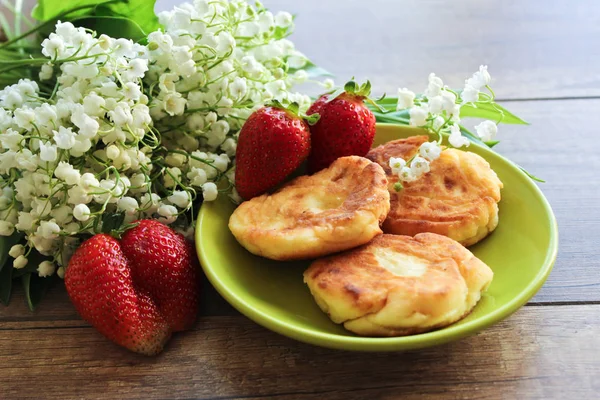 Bahar buket lily vadi, Cheesecakes çilek ile. Süzme peynir cheesecakes kahvaltı. Bahar kahvaltı. — Stok fotoğraf