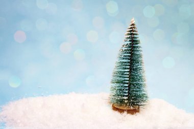 Karda küçük bir oyuncak ağacı, site başlığı için bir afiş.