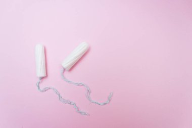 Adet dönemi konsepti. Kadın hijyen koruması. Pembe arka planda pamuk tamponlar. Üst manzara, düz uzanma.