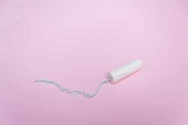 Pembe arka planda regl tamponu. Adet zamanı. Hijyen ve koruma.