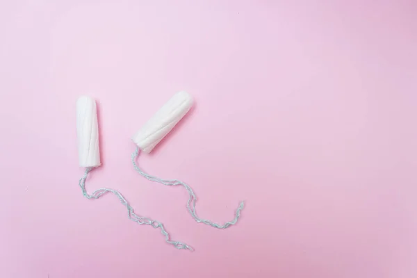 Adet dönemi konsepti. Kadın hijyen koruması. Pembe arka planda pamuk tamponlar. Üst manzara, düz uzanma.