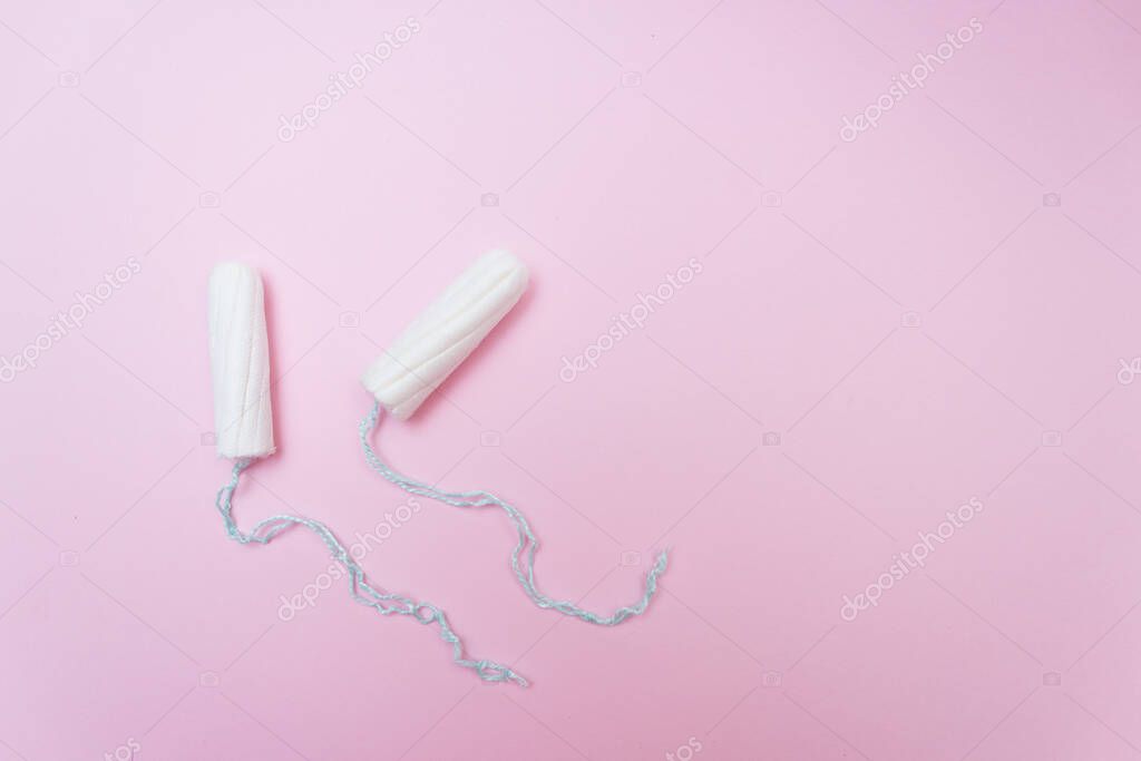 Menstrual period concept. Woman hygiene protection. Cotton tampons on pink background. Top view, flat lay.