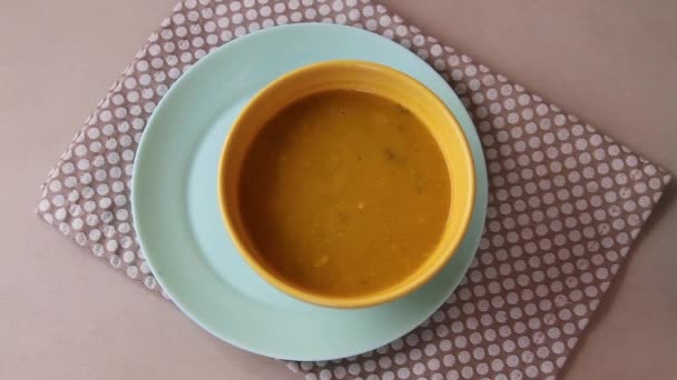 Ženské ruce slouží dýňová a mrkvová polévka v hliněné misce, hliněné nádobí s koprem a pikantní — Stock video